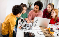 Image of kids working with robots with a teacher